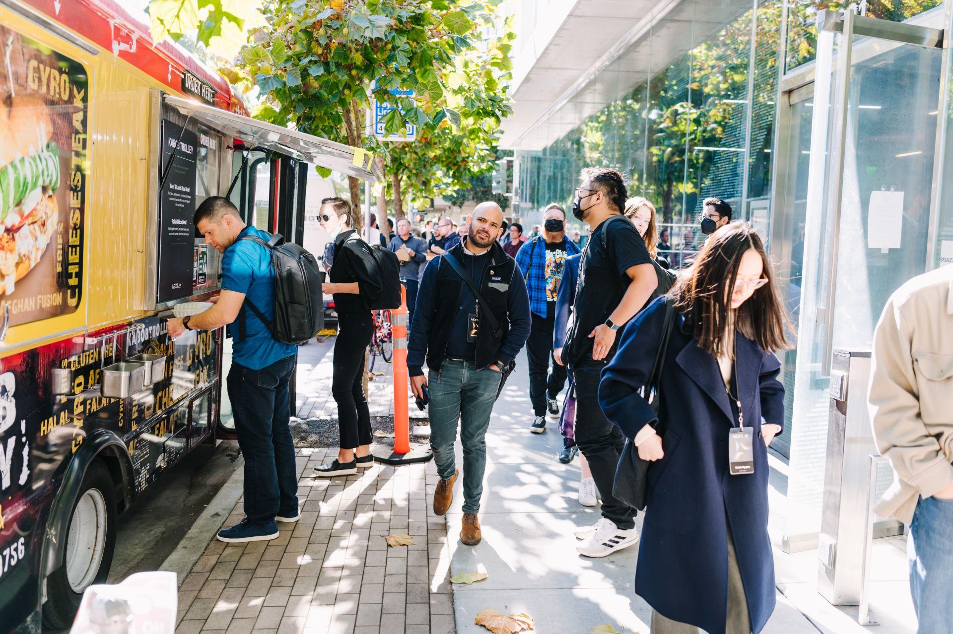 a group of people standing around a food truck