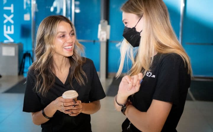 two women in black t - shirts and face masks