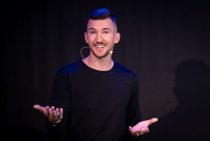 a man in a black shirt is holding out his hands