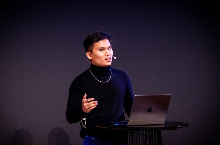 a man presenting in front of a laptop