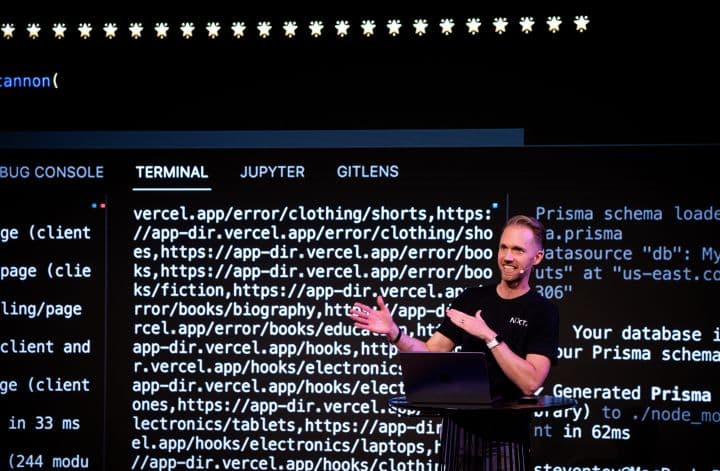 a man standing at a podium in front of a screen