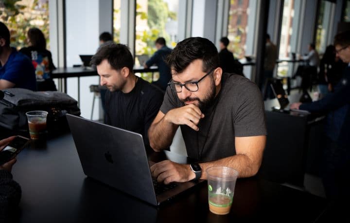 a man sitting at a table using a laptop computer