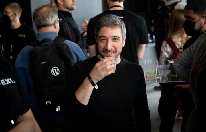 a man holding a drink in front of a group of people