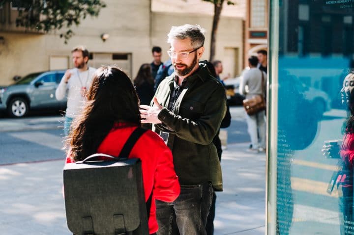 a man standing next to a woman on a sidewalk