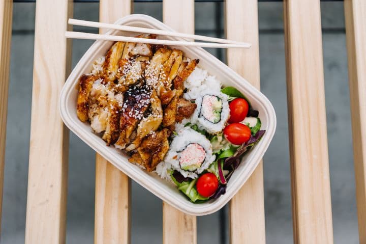 a plastic container filled with food on top of a wooden table