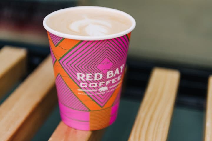 a cup of coffee sitting on top of a wooden table