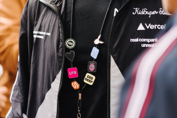 a man wearing a black jacket and a colorful necklace