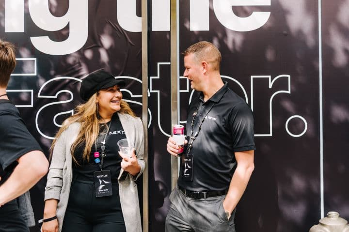 a man standing next to a woman holding a drink