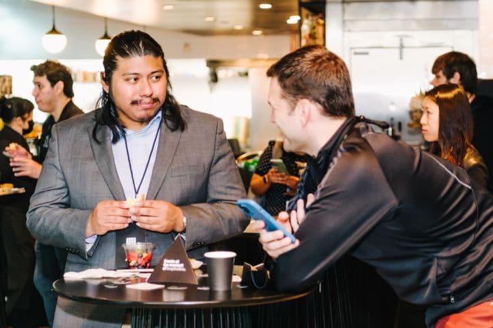 a couple of men standing next to each other at a table