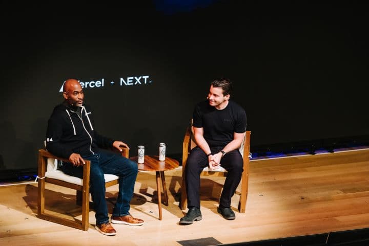 two men sitting on chairs talking to each other