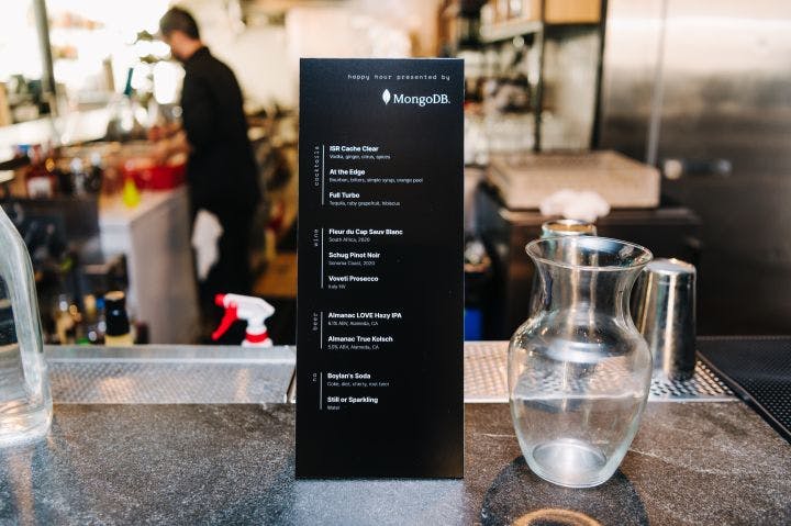 a menu sitting on top of a counter next to a vase