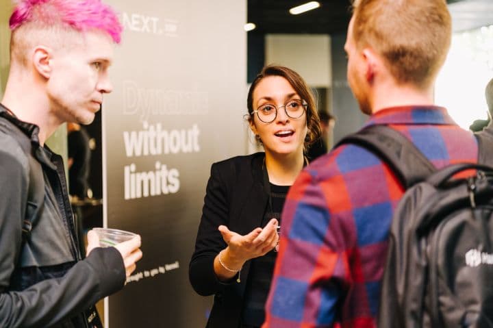 a group of people standing around talking to each other