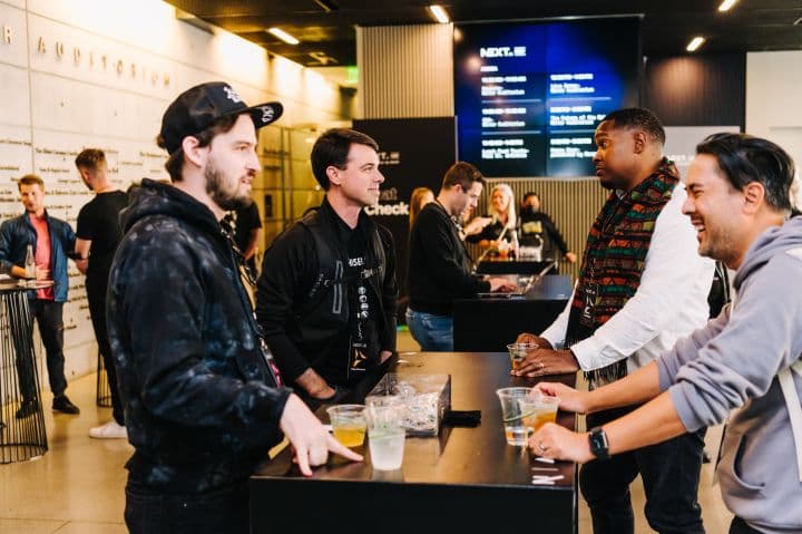 a group of men standing around a table with drinks