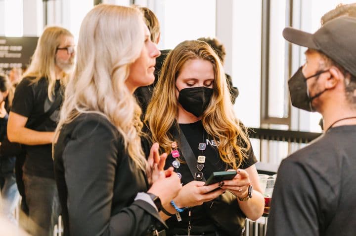 a group of people standing around each other wearing face masks