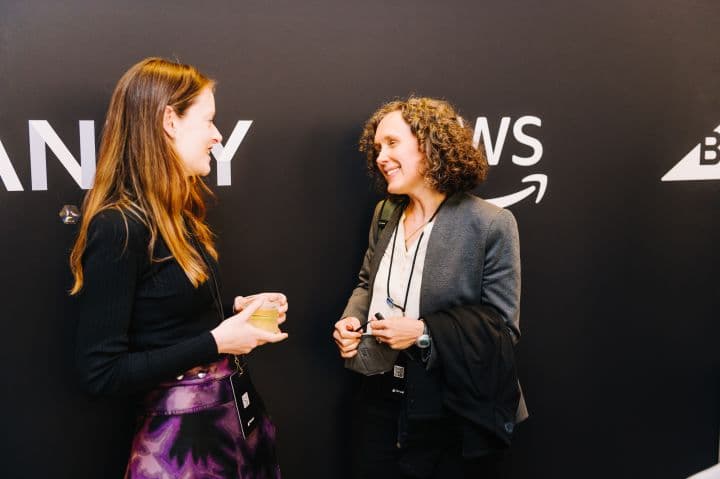 two women standing next to each other talking