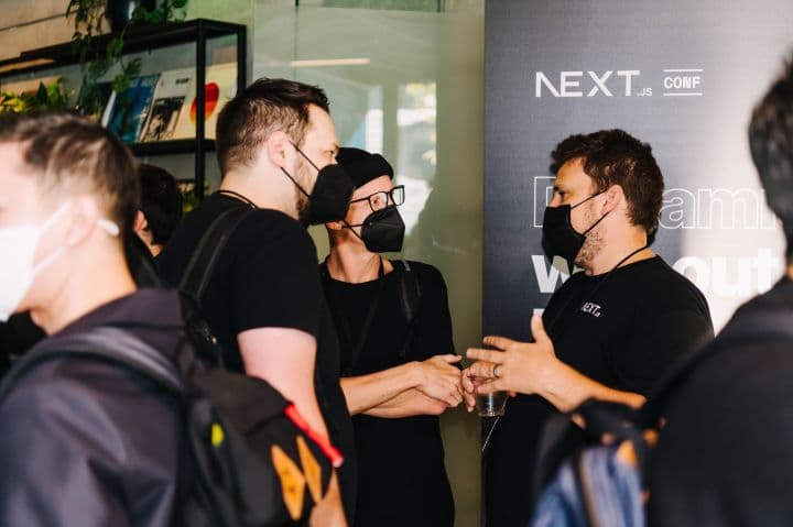 a group of people standing around each other wearing face masks