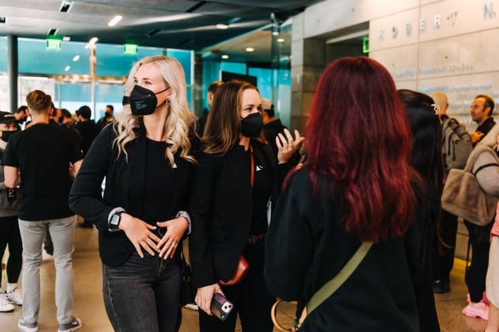 a group of people standing around each other wearing face masks