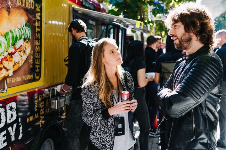 a man and a woman standing in front of a food truck