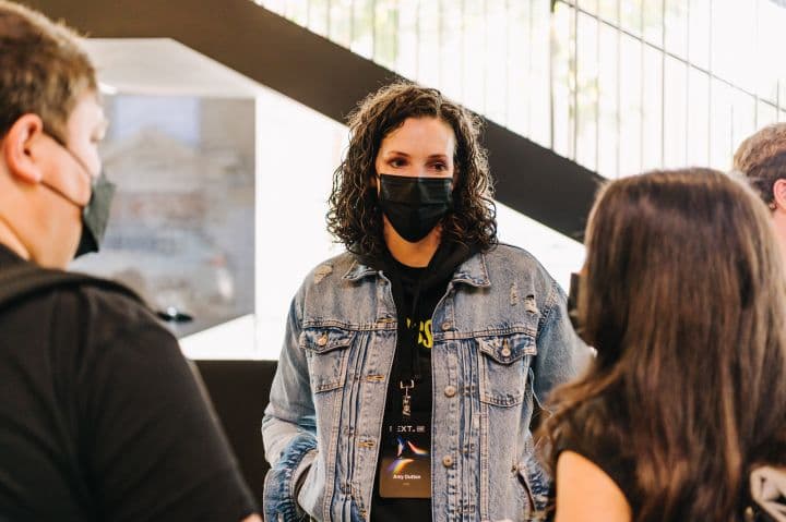 a man wearing a face mask standing in front of a group of people