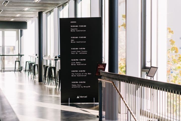 a large black sign in a building with lots of windows