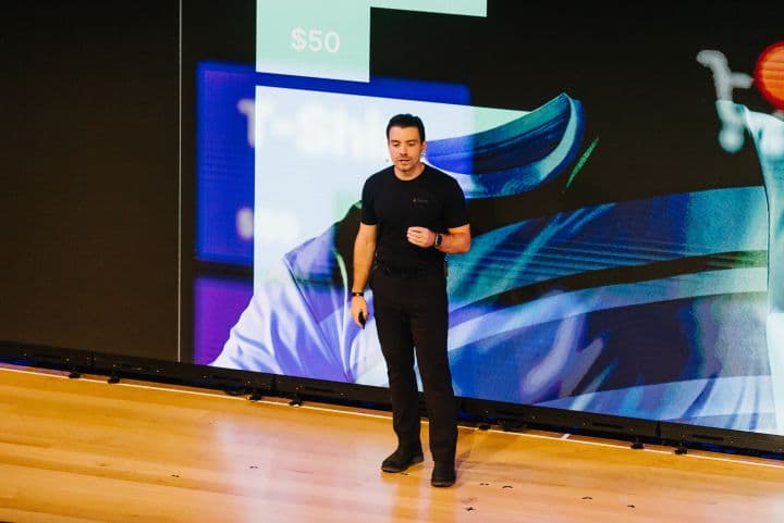 a man standing in front of a large screen