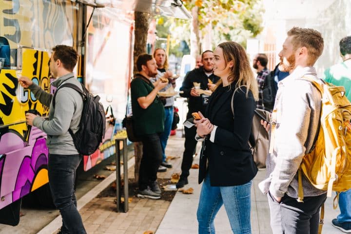 a group of people standing around a food truck