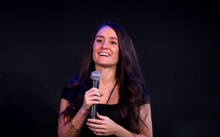 a woman is holding a microphone and smiling