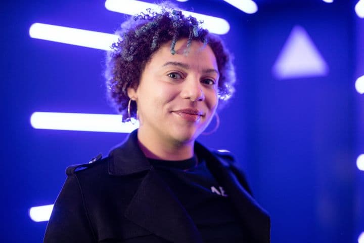 a woman standing in front of a blue background