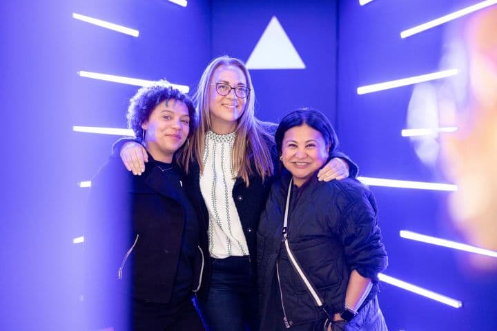 a group of three women standing next to each other