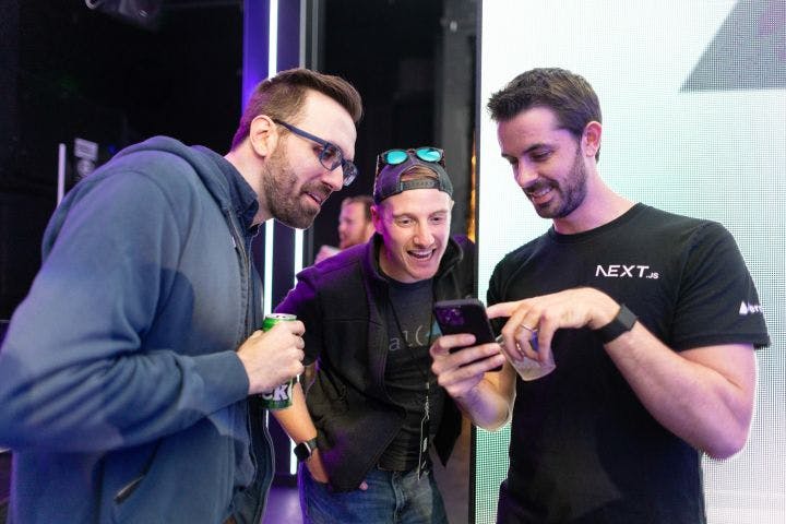 three men are looking at a cell phone