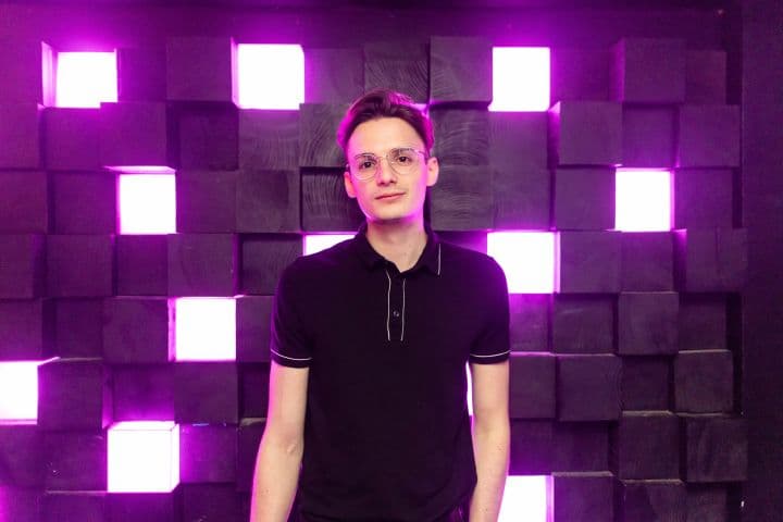 a man standing in front of a purple light