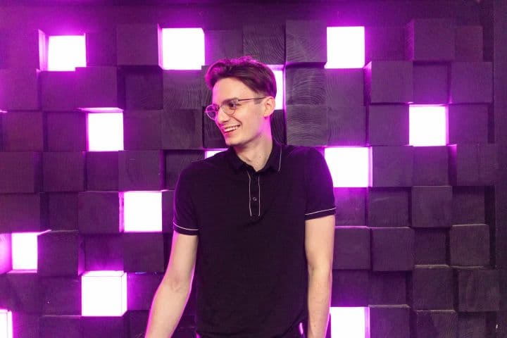 a man standing in front of a purple wall