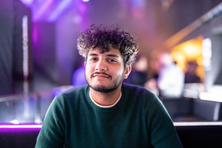 a man with curly hair sitting at a table