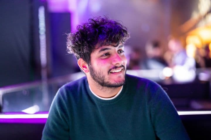 a man with curly hair sitting in a booth