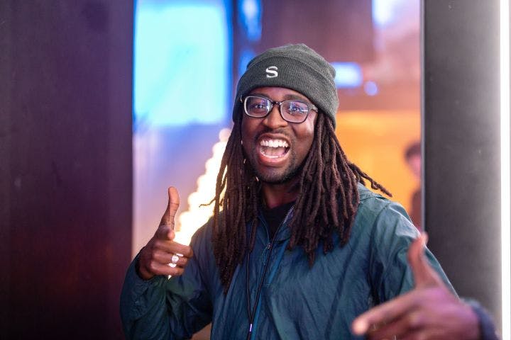 a man with dreadlocks giving a thumbs up