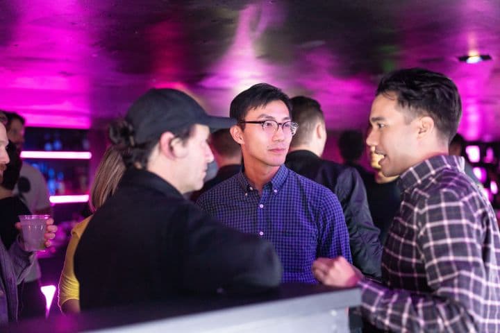 a group of people standing around a bar