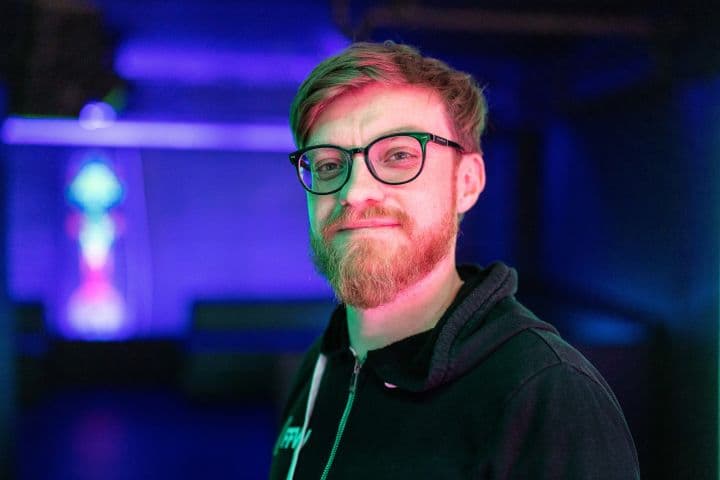 a man with a beard wearing glasses and a hoodie