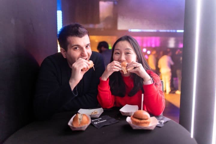 a man and a woman sitting at a table eating food