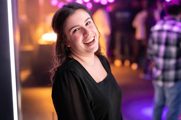 a woman standing in front of a purple light