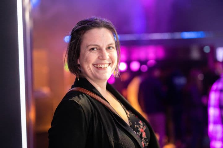 a woman standing in front of a purple light