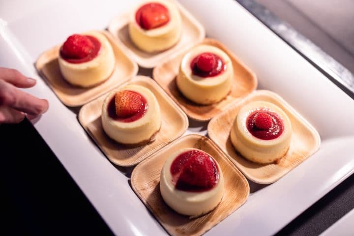 a person is holding a tray of desserts