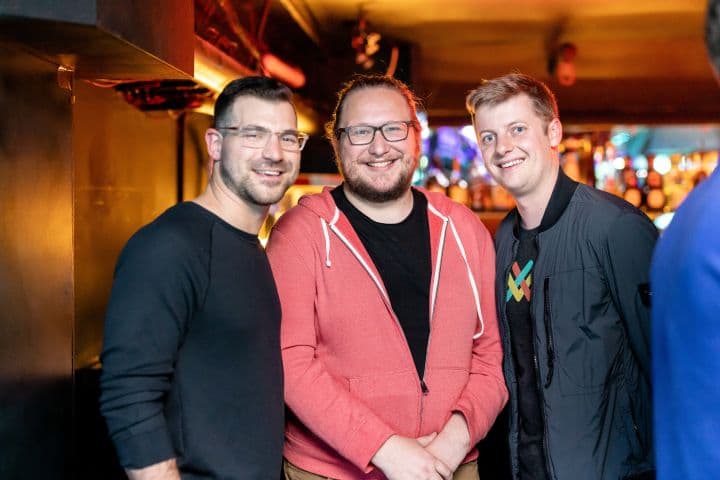 a group of three men standing next to each other